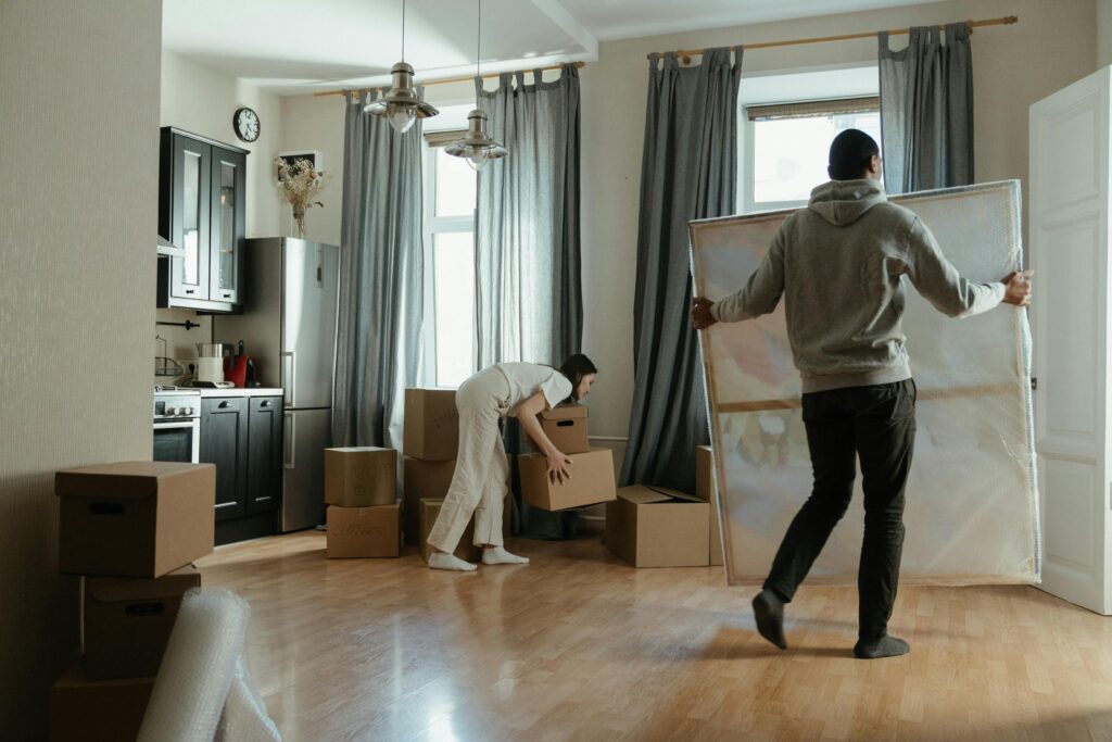 couple carrying boxes and moving out